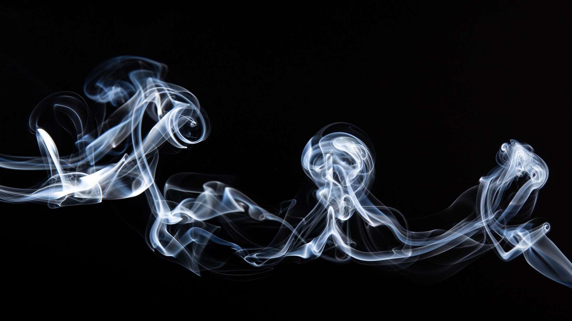 Swirling bright smoke on non-descript black background